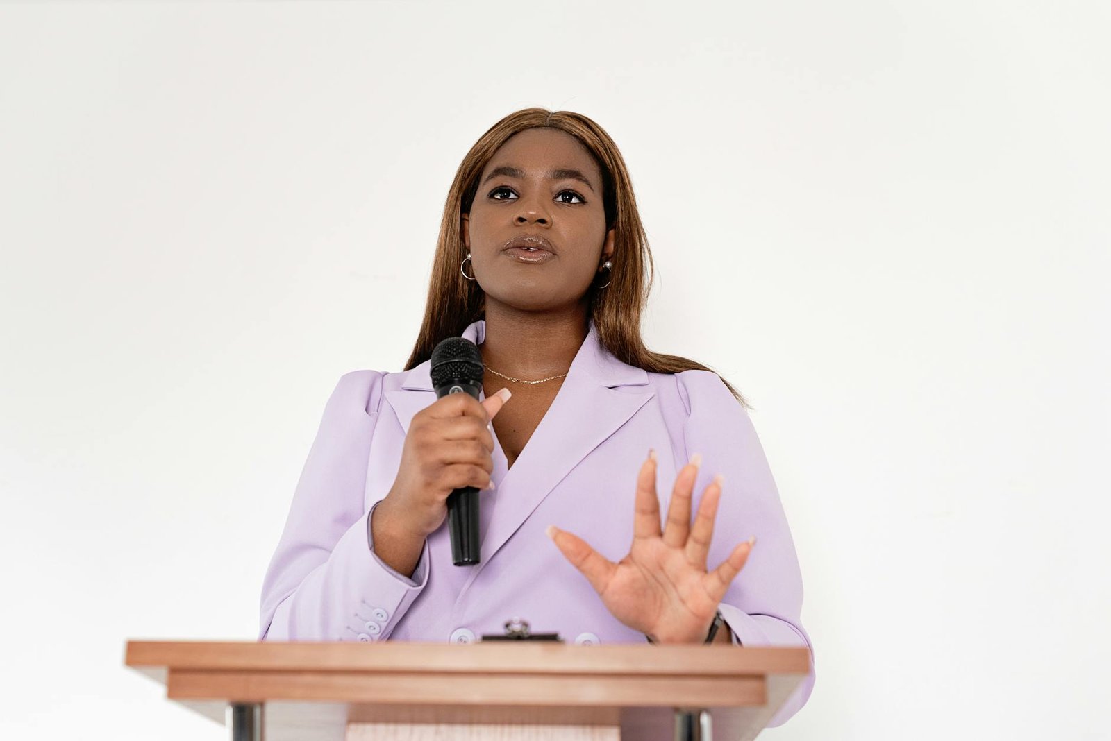 https://www.pexels.com/photo/woman-in-a-blazer-holding-microphone-8872471/